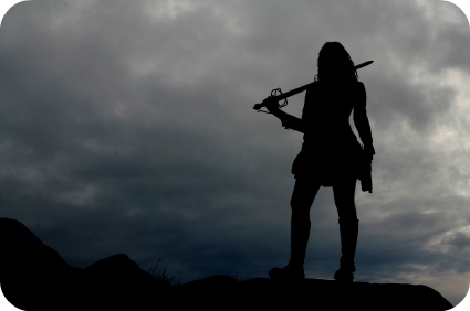 The silhouette of a warrior woman with storm clouds in the background.